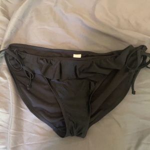 Black swimsuit bottoms with fringe on the front.